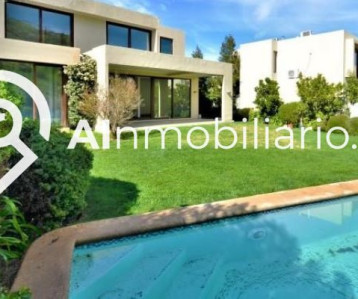 Espacioso jardín con piscina y vista trasera de la casa en venta en Canquén Norte, Chicureo.